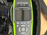 a green and black cell phone in a black bag