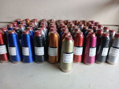 many bottles of different colors of thread on a table