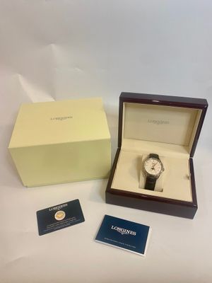 une photo d'une montre dans un coffret et une carte de visite