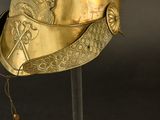 a gold helmet with a horse on it on a stand