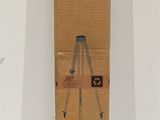 a cardboard box with a tripod on top of it