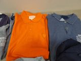 several different colored shirts are lined up on the floor