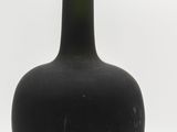 a black bottle with a gold cap sitting on a white surface