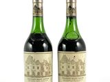 deux bouteilles de vin posées l'une à côté de l'autre sur une surface blanche
