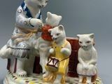 une figurine représentant trois chats assis sur un banc