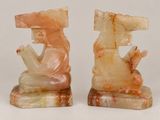 pair of carved bookends of a man and a woman sitting on a rock