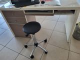 a computer desk with a chair and a laptop on it