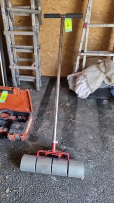 un balai posé par terre à côté d'une boîte à outils