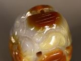 an orange and white glass bead sitting on top of a table
