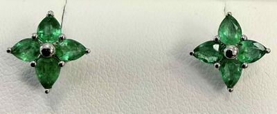 une paire de boucles d'oreilles ornées de pierres vertes sur un fond blanc