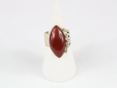 a close up of a ring with a red stone in it