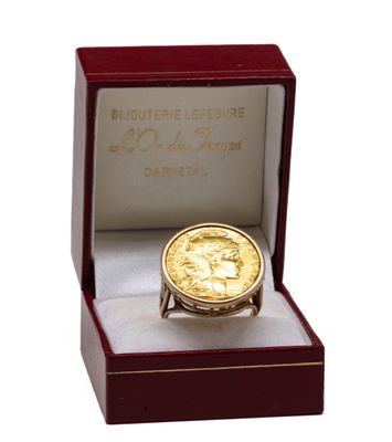 une image représentant une pièce d'or dans une boîte contenant une bague