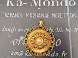 une photo d'un pendentif en or serti d'une perle