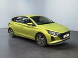 a yellow car is parked in a room with a white wall