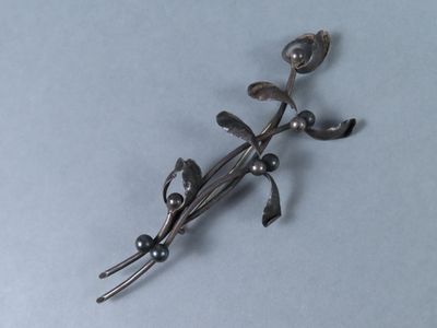une broche en argent surmontée d'un oiseau