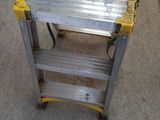 a small metal table with a yellow handle on it