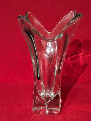 un vase en verre posé sur une surface rouge