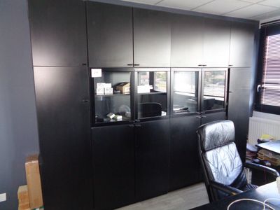 une image représentant un bureau noir avec un bureau et une chaise noire