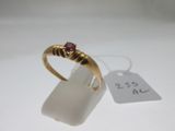 un gros plan d'une bague en or sertie d'un rubis