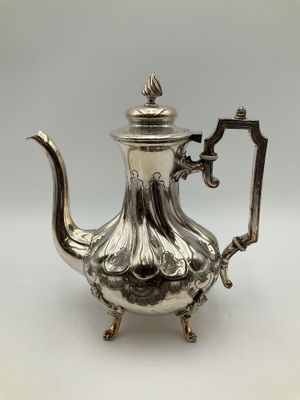une théière en argent munie d'une anse et d'une poignée