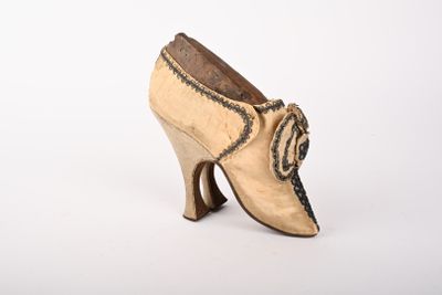an old pair of women ' s shoes on a white surface