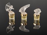 three glass figurines of angels on a black surface