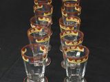 six shot glasses sitting on top of a table with a black background