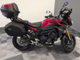 a red motorcycle parked on a checkered tile floor