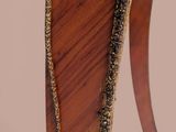 a close up of a wooden table with a gold decoration on it