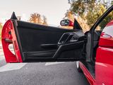 a red sports car with its door open on the street