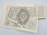 an old map of a city in a book on a table