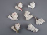 five small white figurines of angels on a gray surface