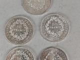 four different coins are shown in a row on a white surface