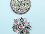 three brooches of different shapes and sizes on a white surface