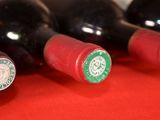 several bottles of wine are lined up on a red surface