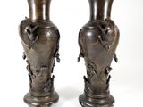 two vases that are sitting side by side on a white surface