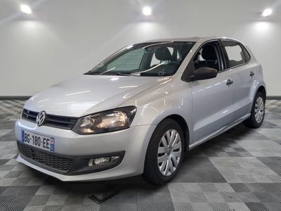 la volkswagen polo blanche est garée dans une pièce au sol à carreaux