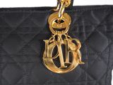 a close up of a black purse with a gold chain