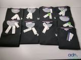 Quatre t-shirts noirs pour homme sont alignés sur une table