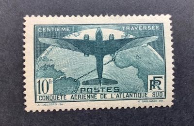 un vieux timbre-poste représentant un avion survolant une chaîne de montagnes