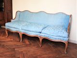 un canapé bleu posé sur un parquet dans un salon