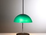 lampe de table verte posée sur une table blanche, sur fond gris