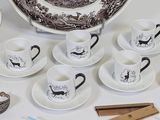 many different types of coffee cups and saucers on the table