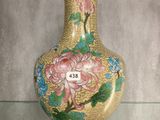 un vase orné de fleurs peintes, posé sur une table en verre