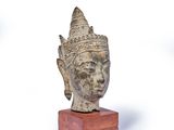 sculpture of a head on a wooden base on a white background