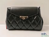 the black purse is sitting on a white surface
