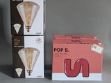 two boxes of light bulbs sitting next to each other on a table
