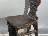 an old wooden chair sitting on top of a tiled floor next to a wall