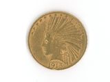 a gold coin with an indian head on it on a white surface