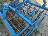 une charrue de tracteur bleue posée par terre